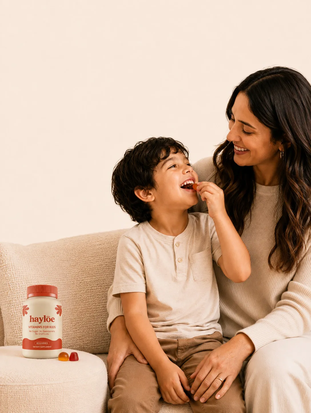 A mother and son share gummies on the sofa, with a jar of Hayloe beside them